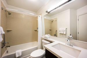 a bathroom with a sink and a tub and a toilet at Sonesta Simply Suites Detroit Troy in Troy