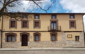 a large stone building with windows and a balcony at House of the Ribera - Quintana del Puente in Quintana del Puente