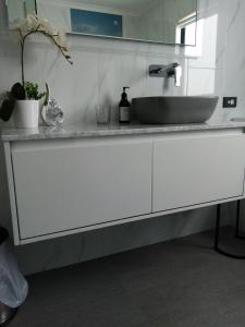 a white bathroom with a sink and a counter at Sunbrae Beach Sands Y in Mount Maunganui