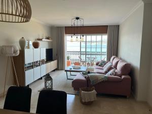 een woonkamer met een bank en een tafel bij Apartamento mirador de tambo in Combarro