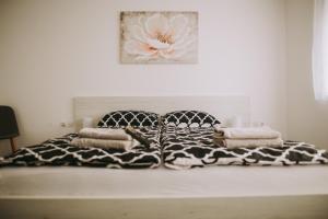 a bed with a black and white blanket and pillows at Kuća za odmor Tamaris in Vukovar