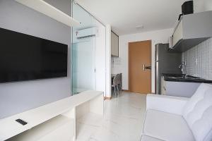 sala de estar con TV de pantalla plana grande en la pared en Refúgio acolhedor com vista mar e piscina compartilhada, en Salvador