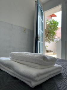 cuatro toallas blancas sentadas sobre una mesa en Casa da Lua Buzios en Búzios