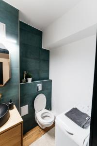 La salle de bains est pourvue de toilettes et d'un lavabo. dans l'établissement Beautiful and cozy 2 bedroom apartment with living room loft, à Cluj-Napoca