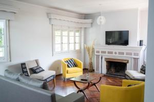a living room with a fireplace and yellow chairs at Amplio y elegante chalet en la mejor zona de Mendoza in Mendoza