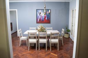 uma sala de jantar com uma mesa branca e cadeiras em Amplio y elegante chalet en la mejor zona de Mendoza em Mendoza