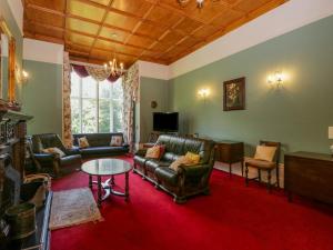 un soggiorno con mobili in pelle e un tappeto rosso di Millwood Manor a Barrow in Furness