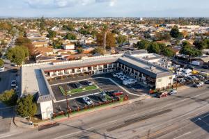 an aerial view of a large building with a parking lot at Aspire Inn Studios & Spas in Bellflower