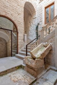 un edificio in pietra con scala e lavandino in pietra di Il Quinto Elemento - Residence Of Charme a Ostuni