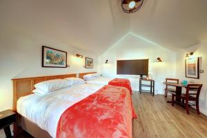 a bedroom with a large bed and a tv at The Seaview Cottages in Seaview