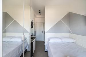 2 camas en una habitación con paredes blancas en VO5 - Studio no Paraíso, Próximo à Paulista e Ibirapuera, com Vaga de Garagem., en São Paulo