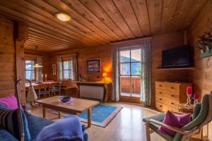 a living room with a table and a tv at Chalets Ebner in Eben im Pongau