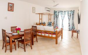 uma sala de estar com uma mesa e uma sala de jantar em Flamingo Naks Suite (Malindi's Hidden Gem) em Malindi