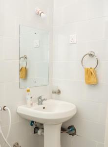 uma casa de banho branca com um lavatório e um espelho em Flamingo Naks Suite (Malindi's Hidden Gem) em Malindi