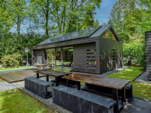 una casa pequeña con una mesa y un banco en Uilenpad 16, en Haaren
