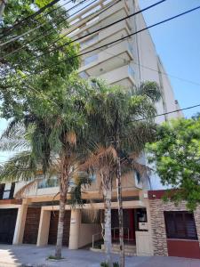 two palm trees in front of a building at Departamento centro Santiago del Estero in Santiago del Estero