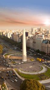 a large white obelisk in a city with traffic at Esmeralda Apartment in Buenos Aires