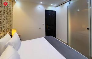 a bedroom with a white bed and a black door at Pyramids View Guest House in Cairo