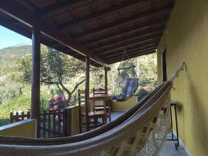 a hammock on the porch of a house at Chalé Limoeiro á 15 minutos de Gonçalves MG in Gonçalves
