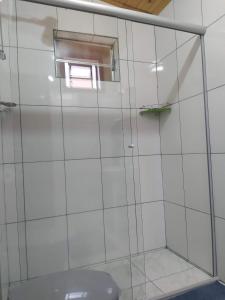 a bathroom with a glass shower with a toilet at Chalé Limoeiro á 15 minutos de Gonçalves MG in Gonçalves