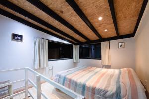 een slaapkamer met een bed en 2 ramen bij Las Martinetas in Santa Rosa de Calamuchita