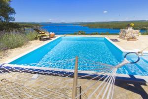 een zwembad met uitzicht op het water bij Family friendly house with a swimming pool Bilice, Krka - 20249 in Šibenik