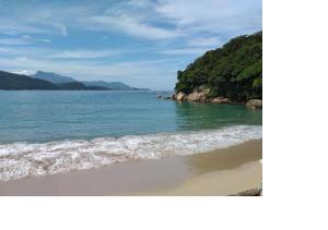 a picture of a beach with the ocean at Pousada Guaruça in Trindade