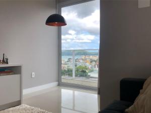 a room with a large window with a city view at Cobertura Duplex - La Belle Vue - Canajurê in Florianópolis