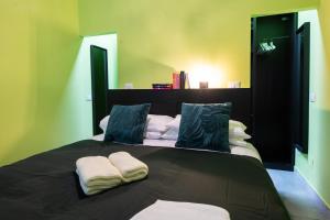 a bedroom with a black bed with two pillows at Casa Vegezio Vaticano adiacente Metro Cipro nuovissimo con giardino privato self check-in in Rome