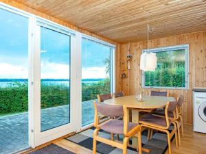 a dining room with a table and chairs and windows at 4 person holiday home in Aabenraa-By Traum in Aabenraa