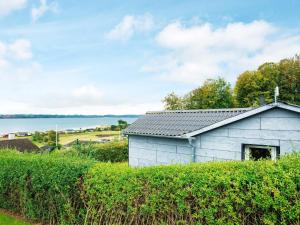 a small white building on a hill next to the water at 4 person holiday home in Aabenraa-By Traum in Aabenraa