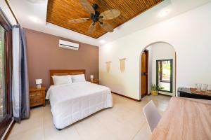 1 dormitorio con 1 cama y ventilador de techo en Hotel Arco Iris en Tamarindo
