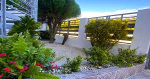 un jardín con flores y plantas en un edificio en Cozy 2BR Near Playa Dorada, 3 Min In Car, en San Felipe de Puerto Plata