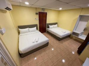 a room with two beds in a room at Hotel Sri Maju Jaya in Kota Bharu +17 photos