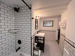 a white bathroom with a tub and a sink at The Seaview Cottages in Seaview