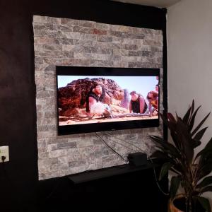 uma televisão de ecrã plano sentada numa parede de tijolos em cabaña mariposa monarca em Mineral de Angangueo