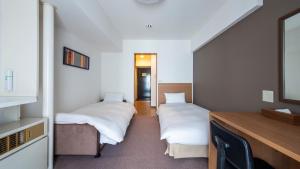 Un pat sau paturi într-o cameră la Hotel Sapporo Met's