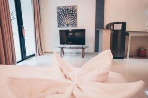 a living room with a white couch and a tv at Alona Northland Resort in Panglao