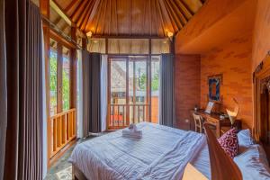 Un dormitorio con una cama en una habitación con ventanas. en Villa Kanha by Bukit Vista, en Jimbaran 15 fotos más