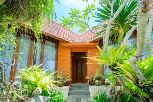 a house in the middle of a garden with trees at Villa Kanha by Bukit Vista in Jimbaran