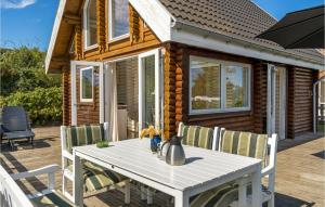 TranekærCozy Home In Tranekær With Kitchen的一个带房屋的甲板上的桌椅