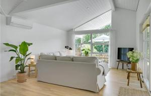 ein Wohnzimmer mit einem weißen Sofa und einem TV in der Unterkunft Lovely Home In Gilleleje With Wifi in Gilleleje