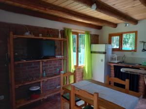 cocina con mesa y TV en una habitación en Duplex Luna en Lago Puelo