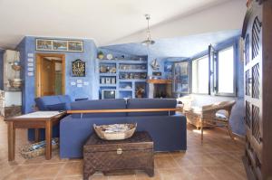 Marine House في كالا غونوني: غرفة معيشة مع جدران زرقاء وأريكة زرقاء