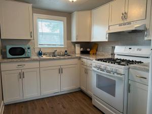 uma cozinha com armários brancos e um forno com placa de fogão em Roomy single bedroom with a huge back yard em Billings