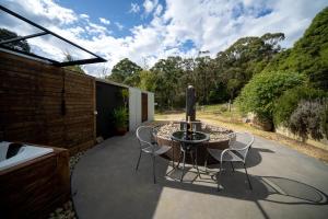 a patio with a glass table and chairs at Deville At Healesville in Healesville
