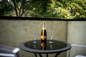 Una botella de champán en una mesa con dos copas. en Deville At Healesville, en Healesville