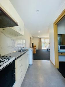 a kitchen with white cabinets and a stove top oven at Nagambie Motor Inn and Conference Centre in Nagambie