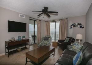 a living room with a couch and a flat screen tv at Shoalwater 802 in Orange Beach