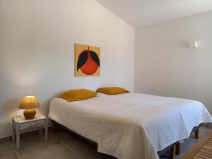 a bedroom with a bed and a painting on the wall at Tasi Ingrina in Vila do Bispo